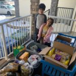 Two children help with the community Ayyám-i-Há food donation project.